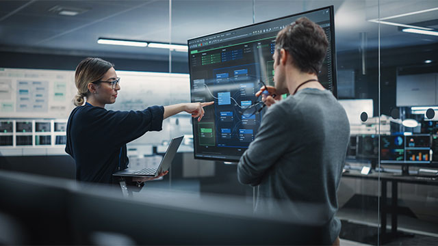 Two Diverse Software Developers Having a Meeting in a Conference Room