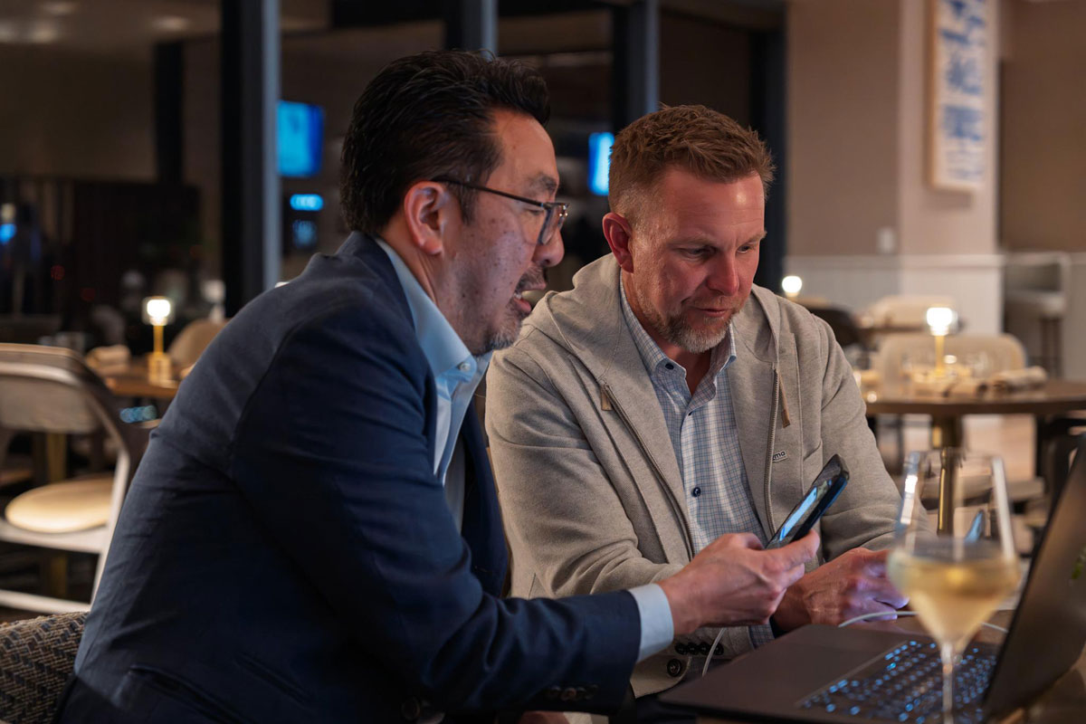 Men converse at a tradeshow cafe